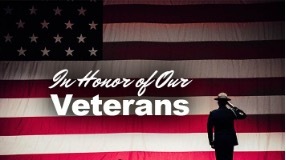 In Honor of Our Veterans, with the American flag and a Veteran saluting in the distance.